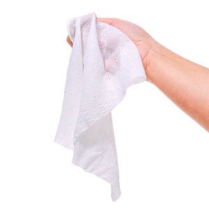 Hand holding a white towel against a white background