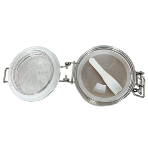 Tea infuser with mesh basket and white spoon on a white background