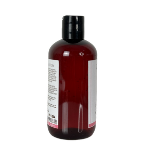 Bottle of red liquid with a black cap on a white background