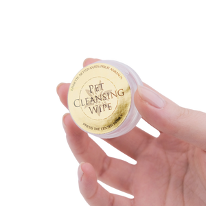 Hand holding a container of Pet Cleansing Wipes with a gold label.