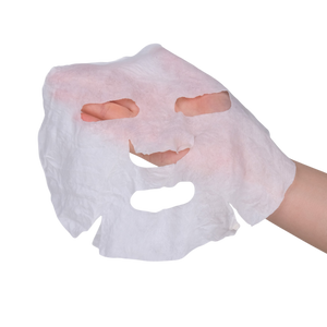 Hand holding a white face mask with cutouts for eyes and mouth on a white background