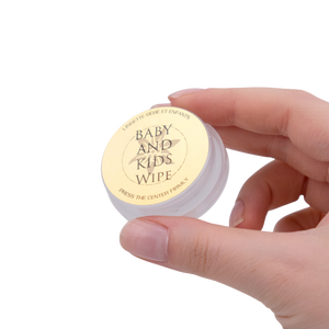 Hand holding a container labeled 'Baby and Kids Wipe' on a white background
