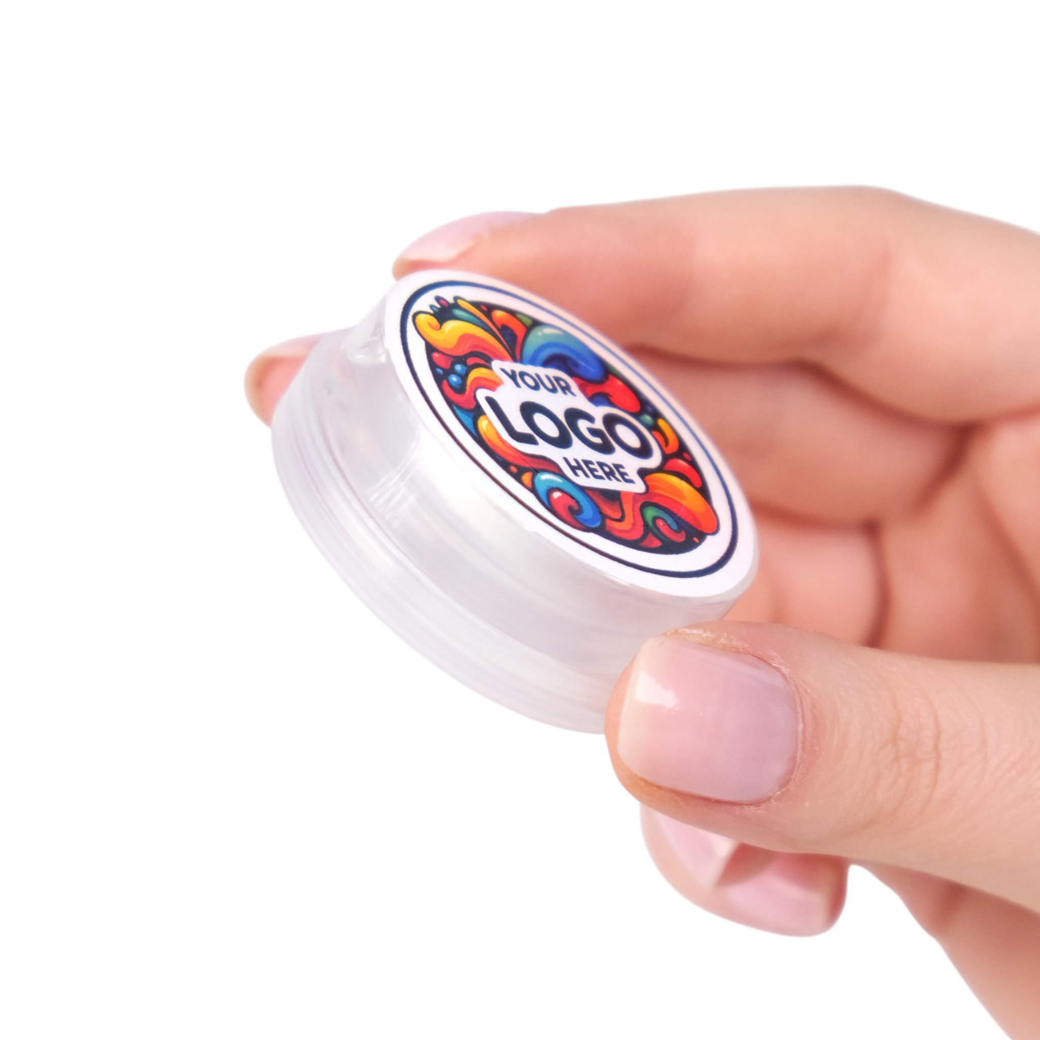 Hand holding a small container with a colorful logo on a white background