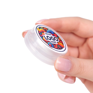 Hand holding a small container with a colorful logo on a white background