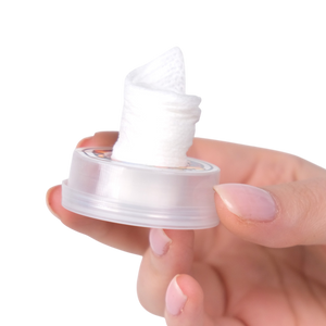 Hand holding a clear plastic container with a white cap on a white background