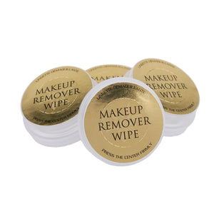 Makeup remover wipes with gold labels on a white background