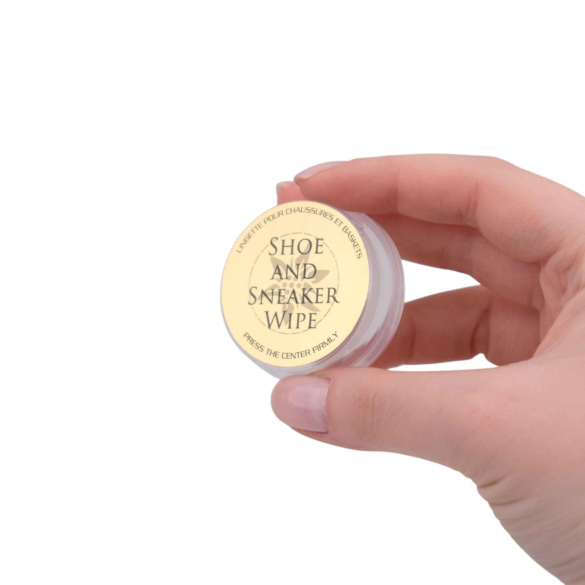 Hand holding a small container labeled 'Shoe and Sneaker Wipe' against a white background