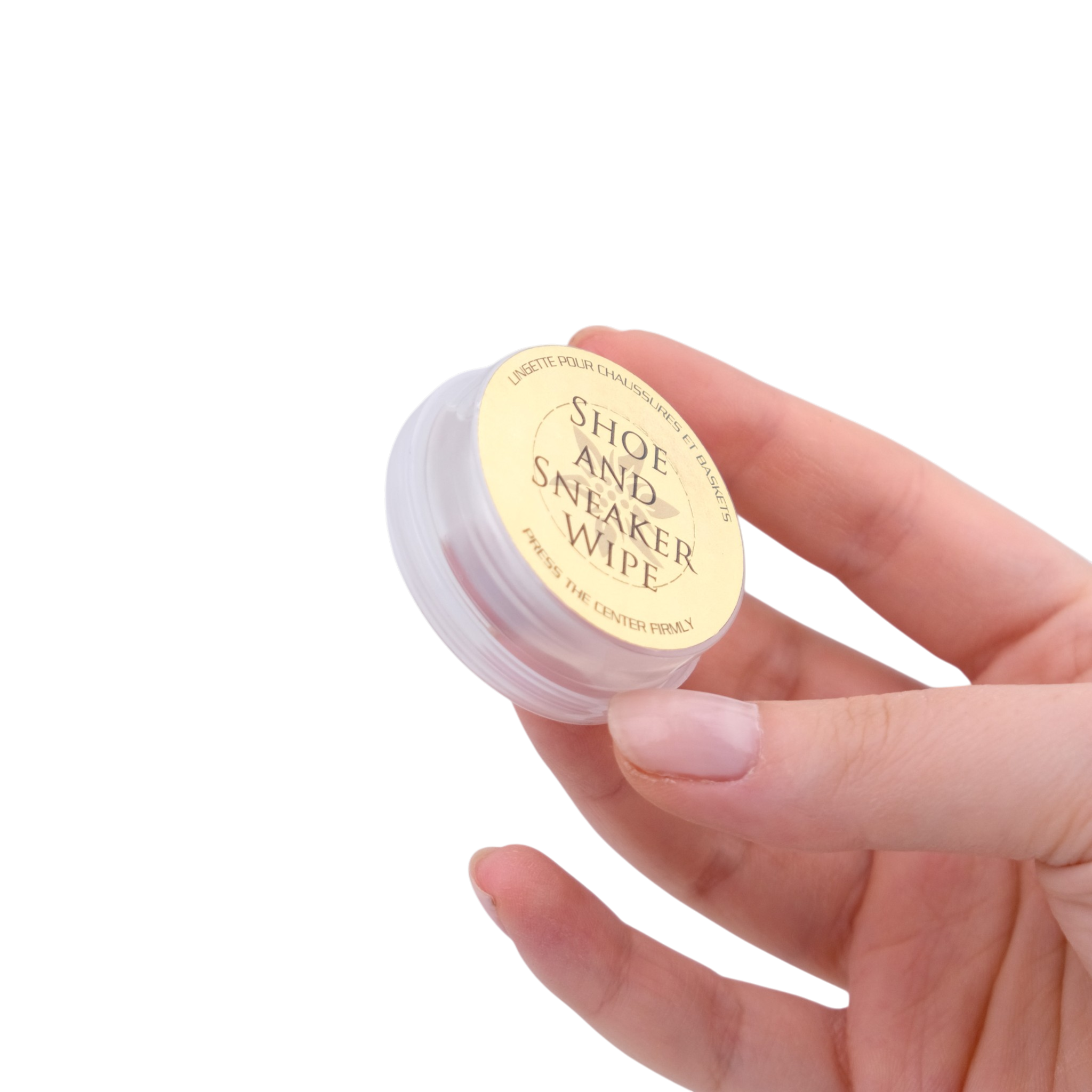 Hand holding a small container labeled 'Shoe and Sneaker Wipe' against a white background