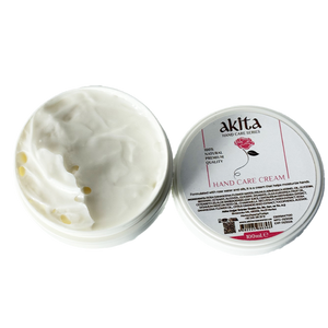 Open jar of hand care cream with visible cream and 'akita' branding on a white background