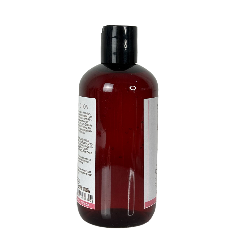 Bottle of red liquid with a black cap on a white background
