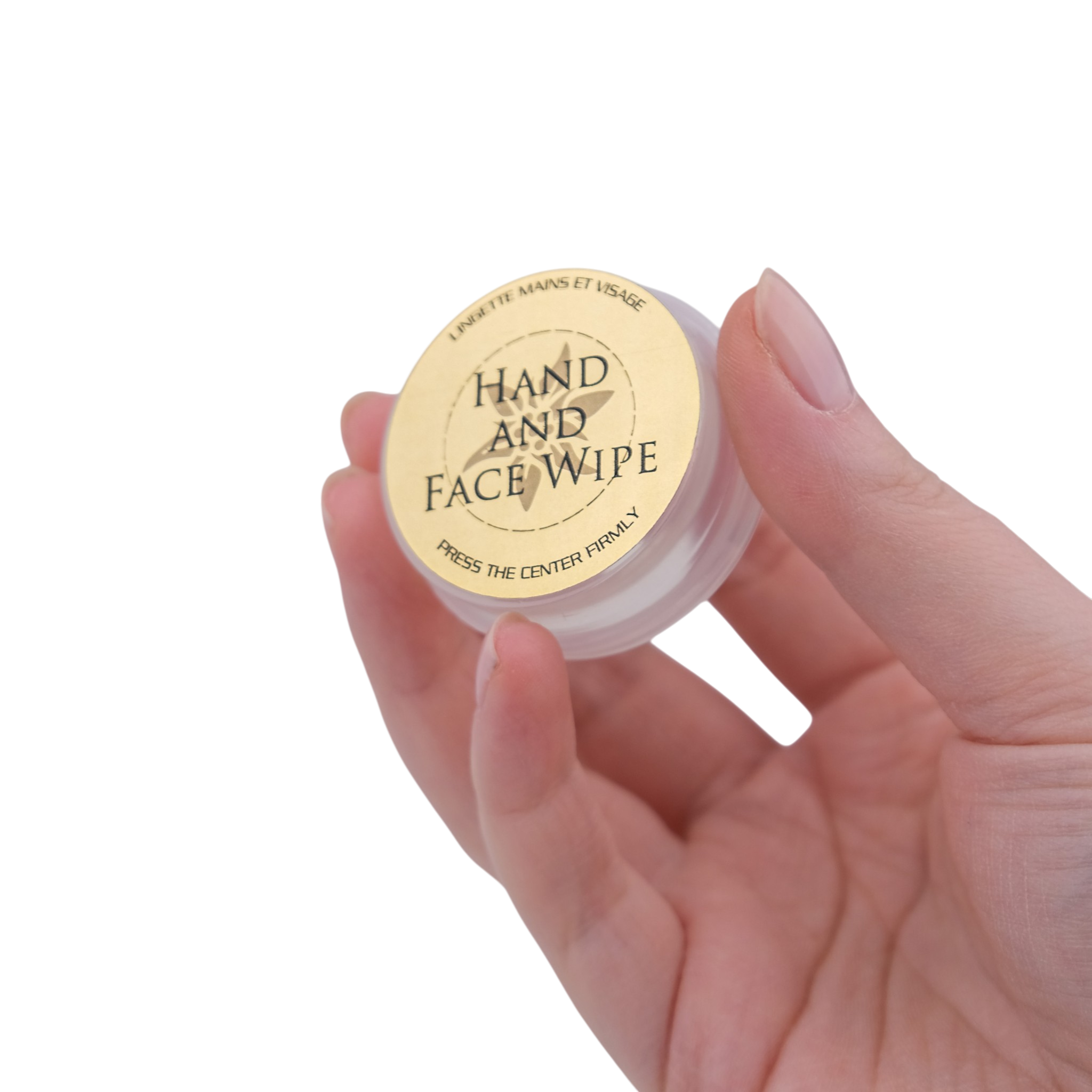 Hand holding a small container of 'Hand and Face Wipe' with a visible label.