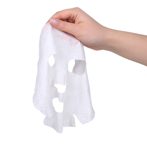 Hand holding a white paper towel with cut-out shapes on a white background